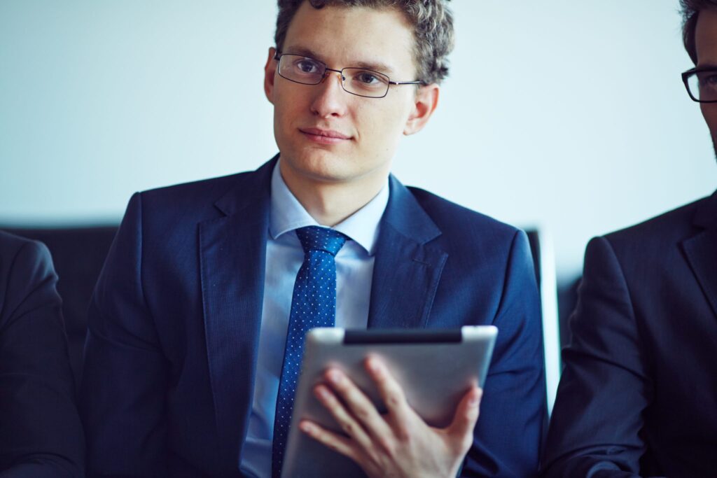Homme en costume tenant une tablette
