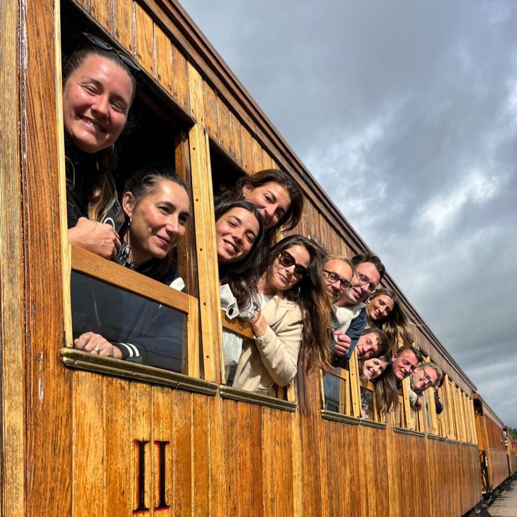 Groupe souriant aux fenêtres d’un train ancien